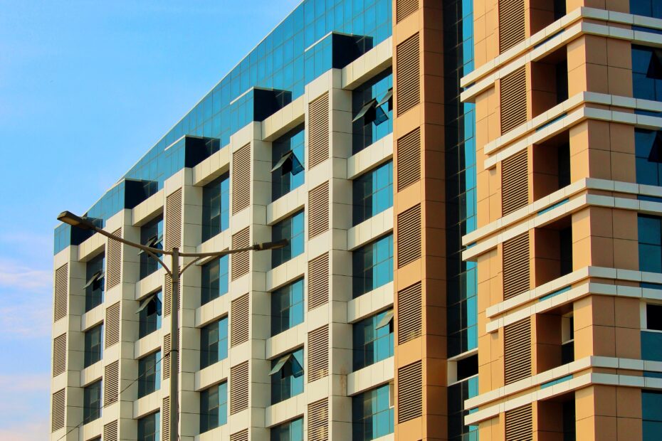 Ein modernes Bürogebäude mit blauen Glasfenstern unter klarem Himmel.